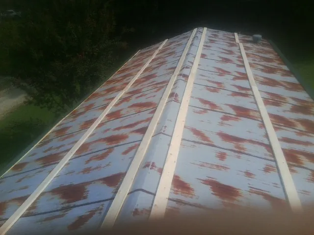 Rusted metal roof panels with new wood purlins before replacement — Storm Damage Roof Repair in Guy by Roofing Brothers